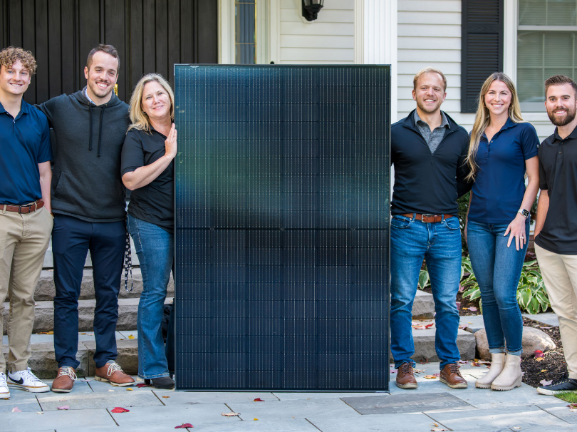 Hello Sunray family owned business smiling in group around the hello sunray solar panel